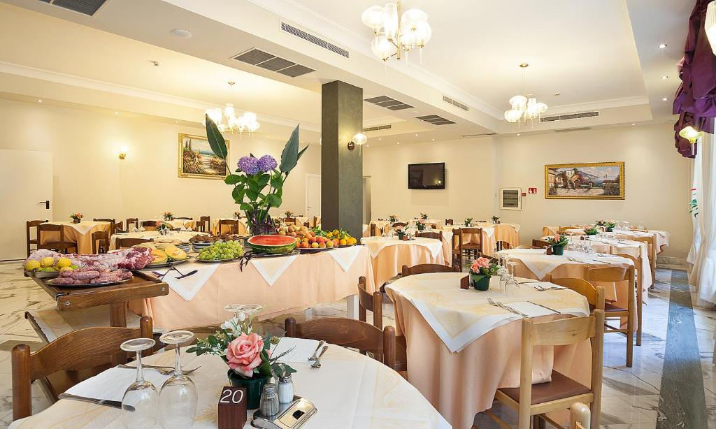un restaurant avec des tables et des chaises avec des fleurs dessus dans l'établissement Hotel Club, à Sant'Agnello