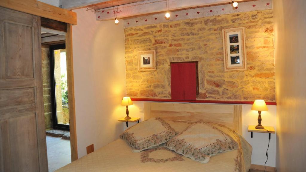 - une chambre avec un lit et deux lampes murales dans l'établissement Gites de Combarel, à Corn 34 autres photos