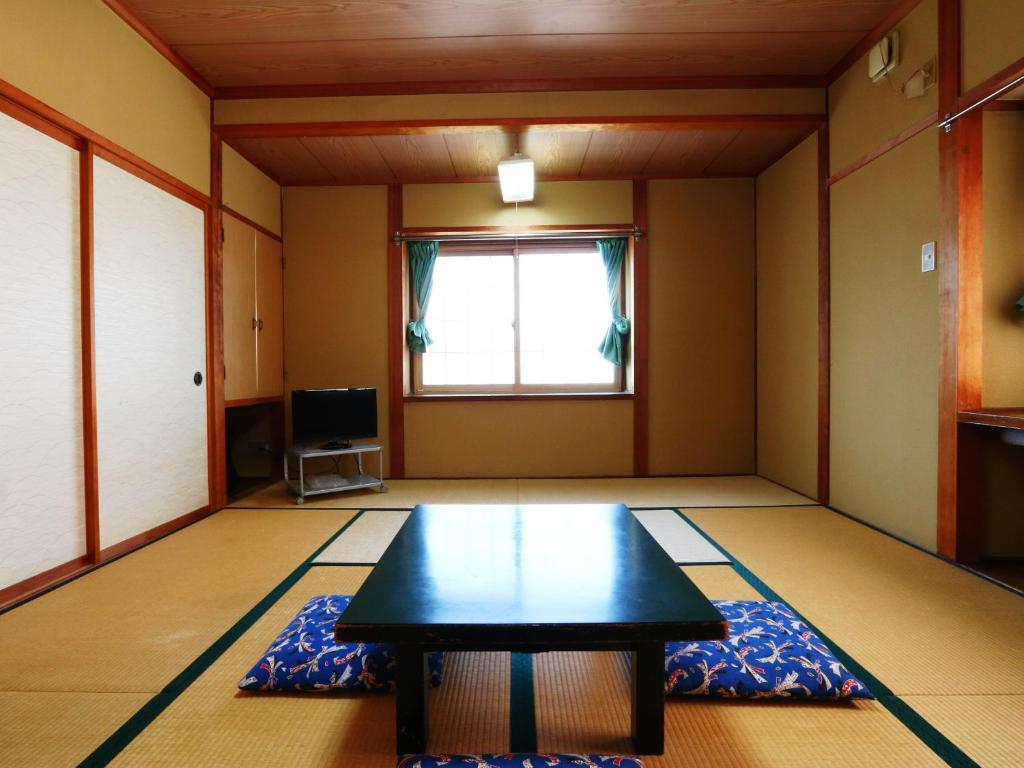 une chambre avec une table au milieu d'une pièce dans l'établissement Hakuraiso, à Matsumoto