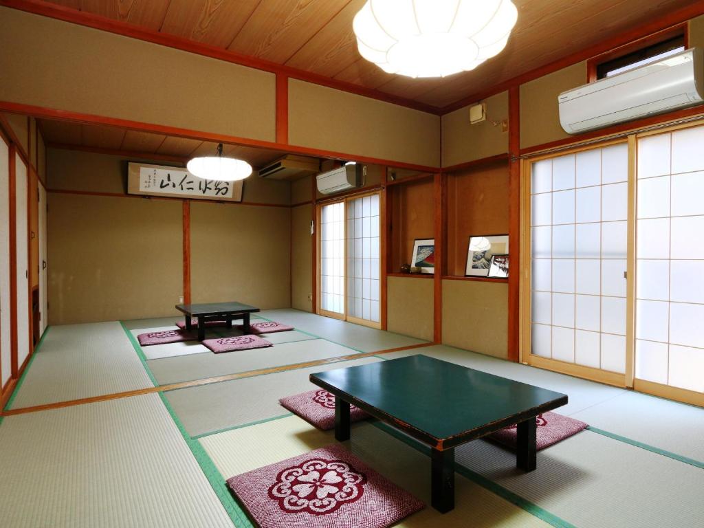 - une salle de méditation avec une table et des tapis au sol dans l'établissement Hakuraiso, à Matsumoto