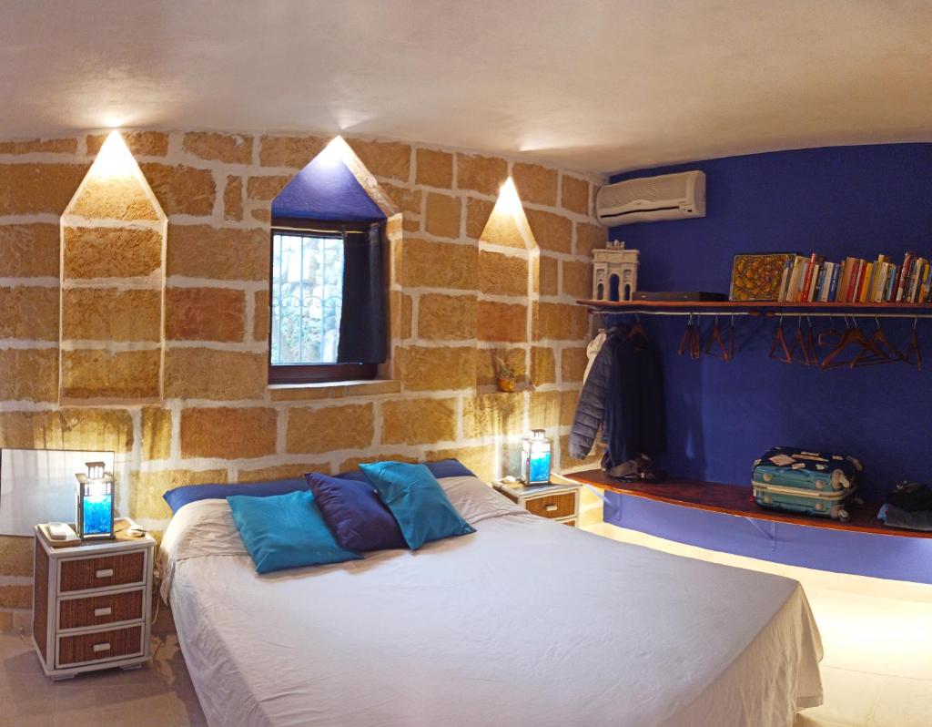une chambre avec un grand lit avec des oreillers bleus dans l'établissement VILLE GIRASOLI "VILLA NELLA BAIA" with PRIVATE SWIMMING POOL, à Tricase 94 autres photos