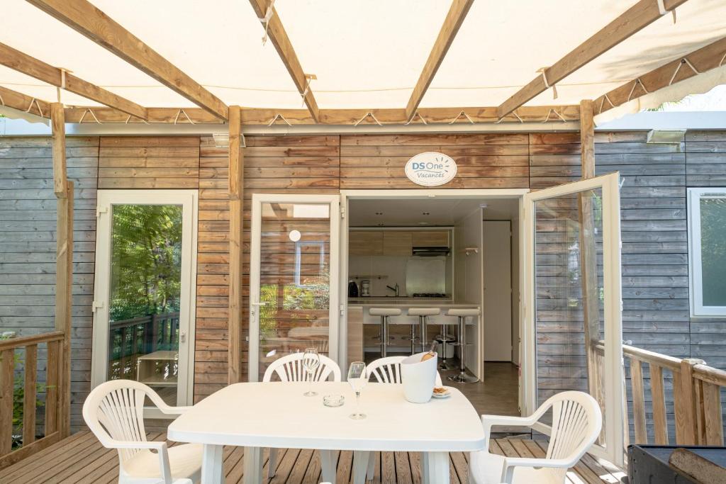 un patio avec une table et des chaises sur une terrasse dans l'établissement Marino Mobilhomes, à Grimaud