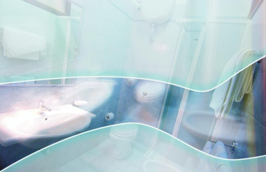 une salle de bain avec un lavabo et des toilettes dans l'établissement Hotel Rio, à Vasto
