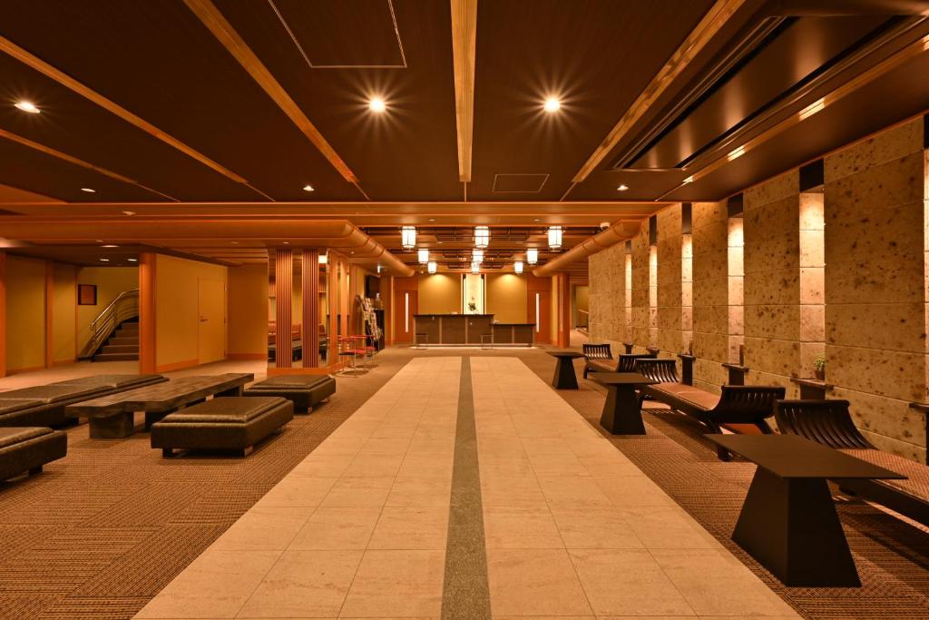 un couloir avec des bancs et des tables dans un bâtiment dans l'établissement Biwako Hanakaido, à Ōtsu