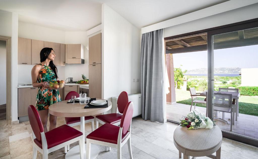 une femme debout dans la cuisine d'une maison dans l'établissement Grande Baia Resort & Spa, à San Teodoro