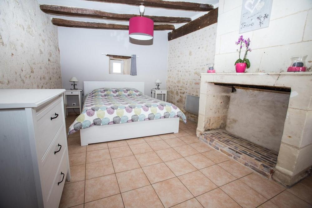 une chambre avec un lit et une cheminée dans l'établissement Charme et Spa dans un domaine d'élevage, à Sennevières 16 autres photos