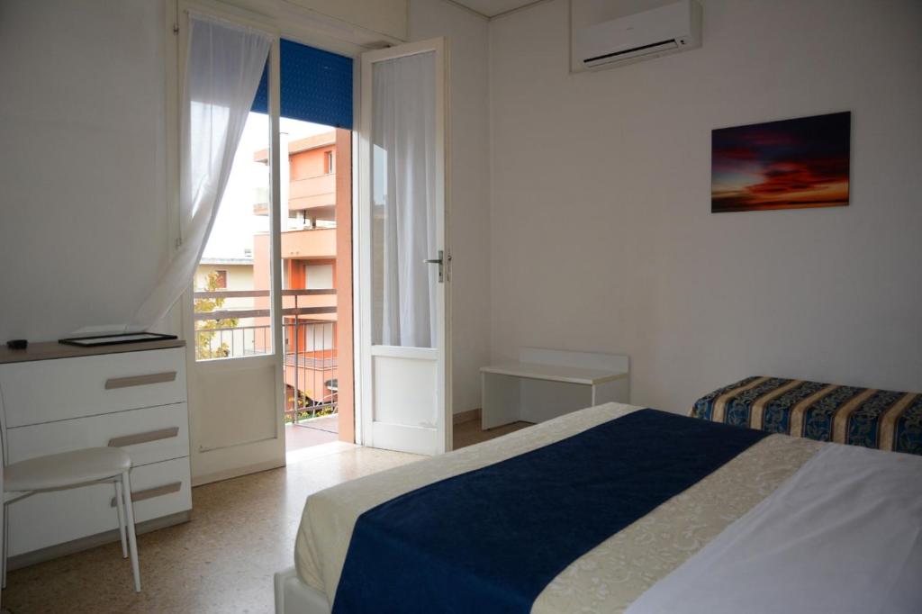 une chambre blanche avec un lit et un balcon dans l'établissement Dea Della Salute Hotel, à Bellaria-Igea Marina