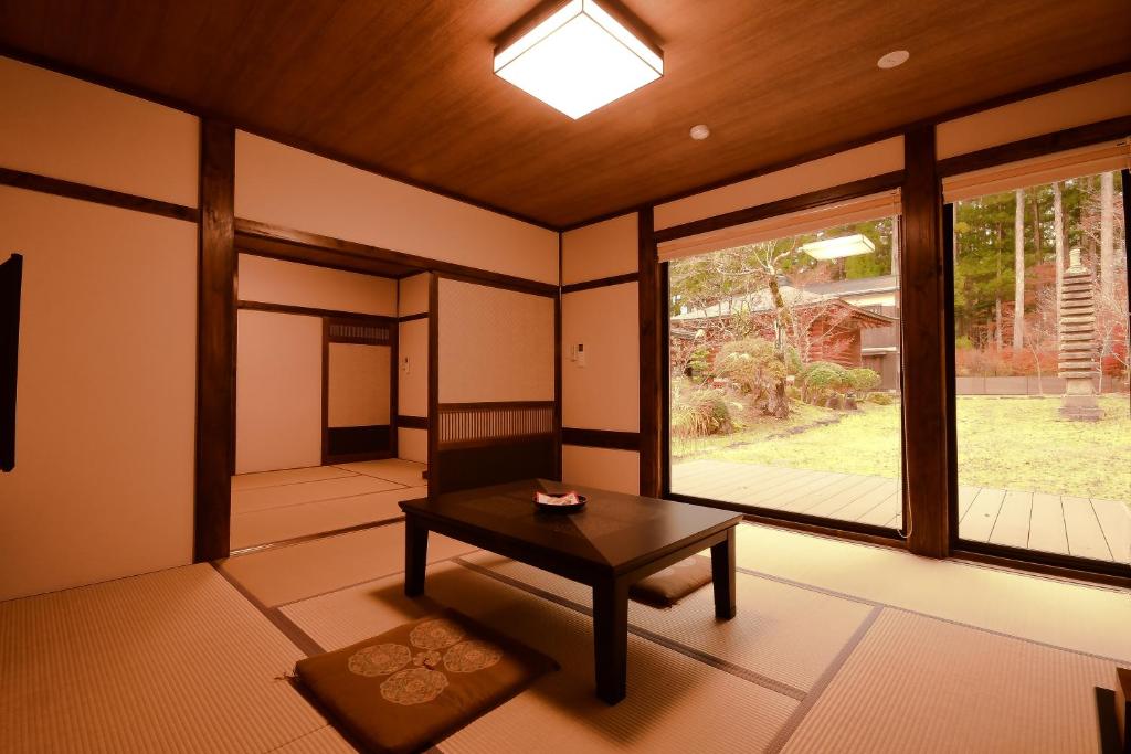 une pièce avec une table et une grande fenêtre dans l'établissement Koyasan Shukubo Jokiin, à Koyasan