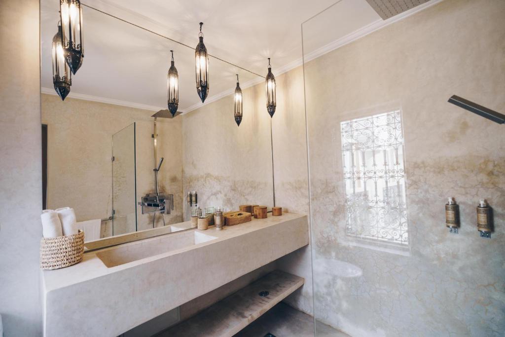 une salle de bain avec un lavabo et un miroir dans l'établissement Riad Bamboo Suites & Spa, à Marrakech