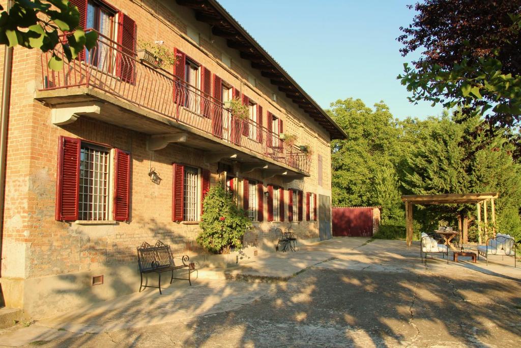 un bâtiment avec des tables et des chaises devant lui dans l'établissement Villa La Mura - Luxury Pool by the Vineyard, à Costigliole dʼAsti