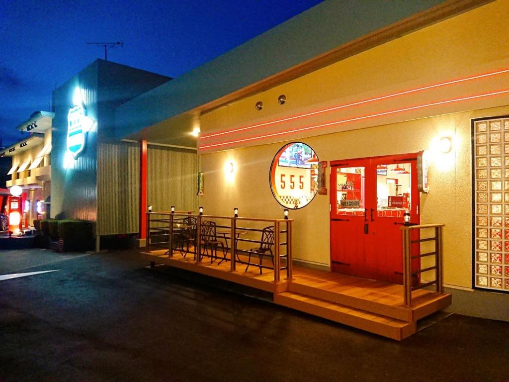 un restaurant avec une porte rouge dans une rue dans l'établissement 555 MOTEL GOTEMBA, à Gotemba