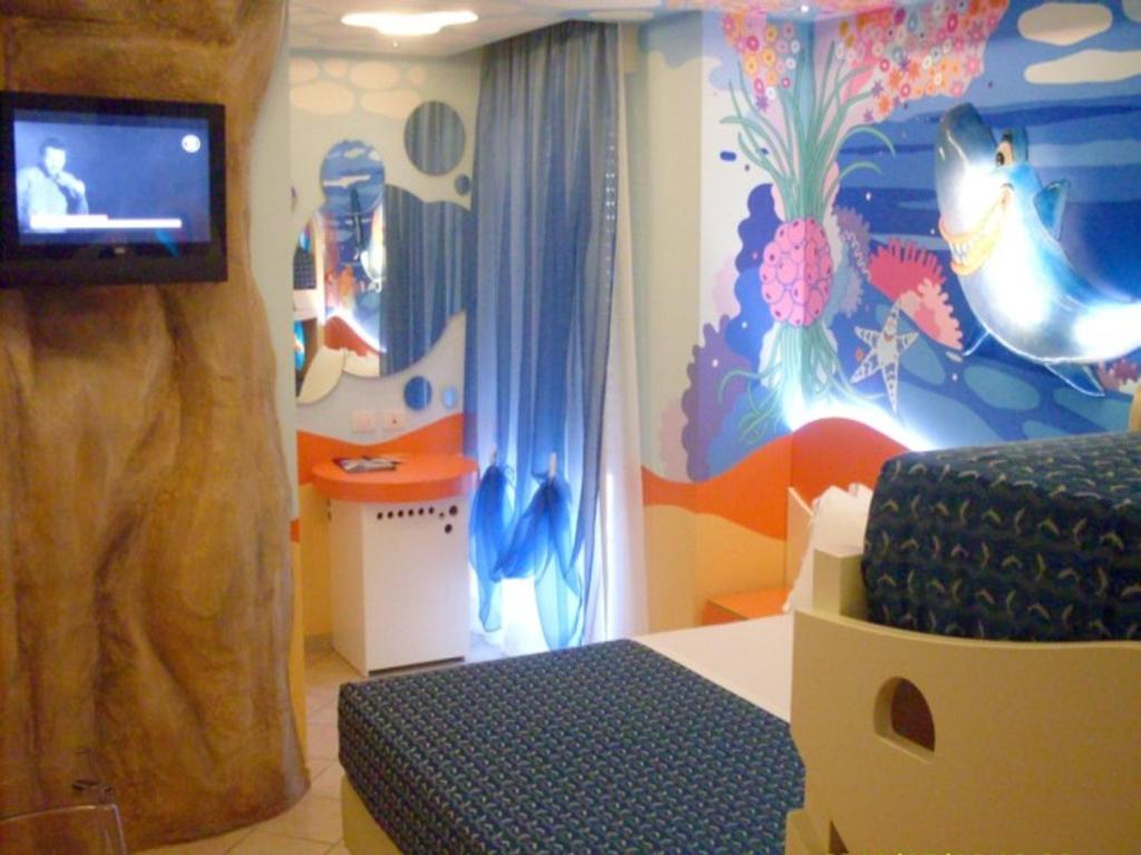 une pièce avec une chambre avec un mur sur le thème des dauphins dans l'établissement Hotel La Cappuccina, à Riccione
