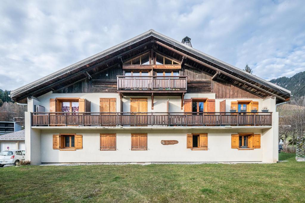 une maison avec un balcon sur le côté dans l'établissement Fleur des Montagnes, à Praz-sur-Arly