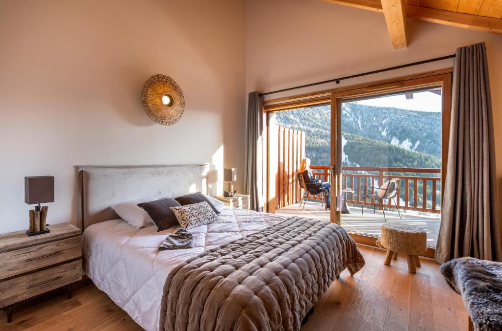 une chambre avec un lit et un balcon avec vue dans l'établissement TERRESENS - Le Saphir, à Vaujany