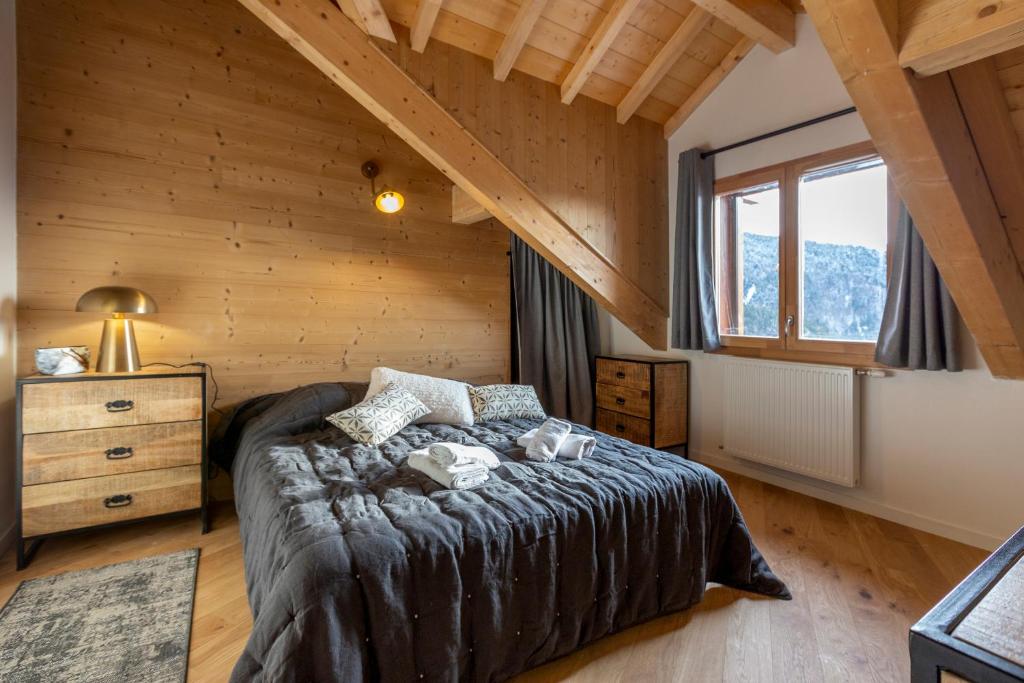 - une chambre avec un lit dans une maison en bois dans l'établissement TERRESENS - Le Saphir, à Vaujany