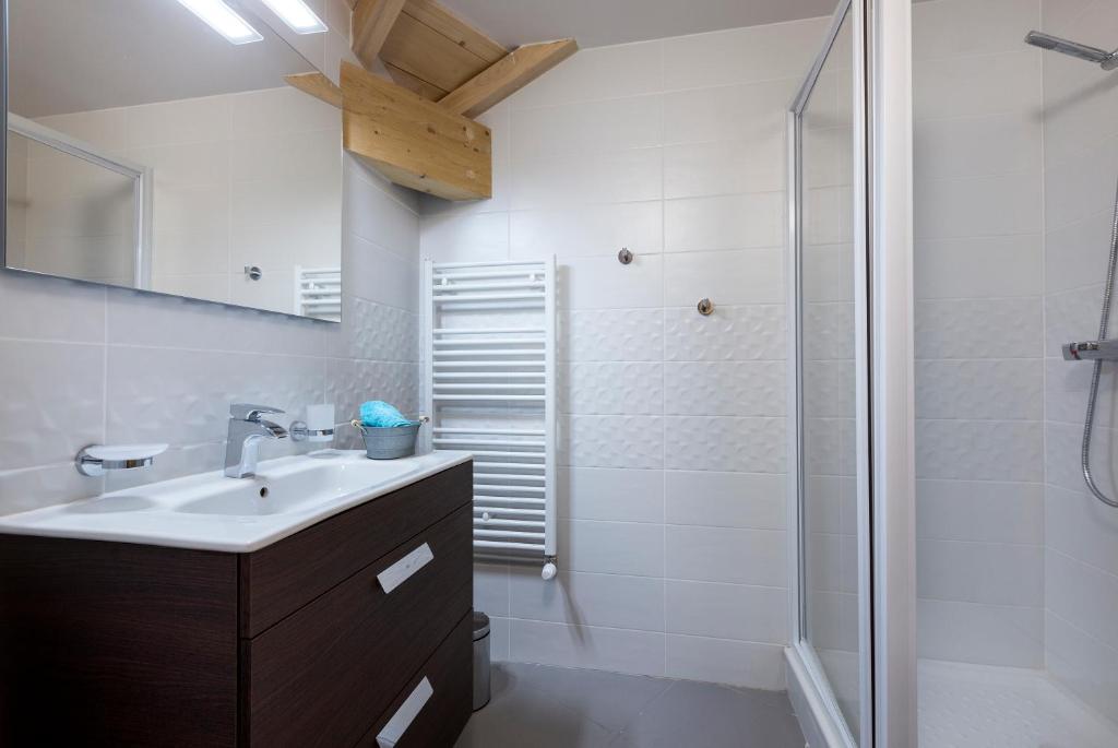une salle de bain avec un lavabo et une douche dans l'établissement TERRESENS - Le Saphir, à Vaujany 31 autres photos