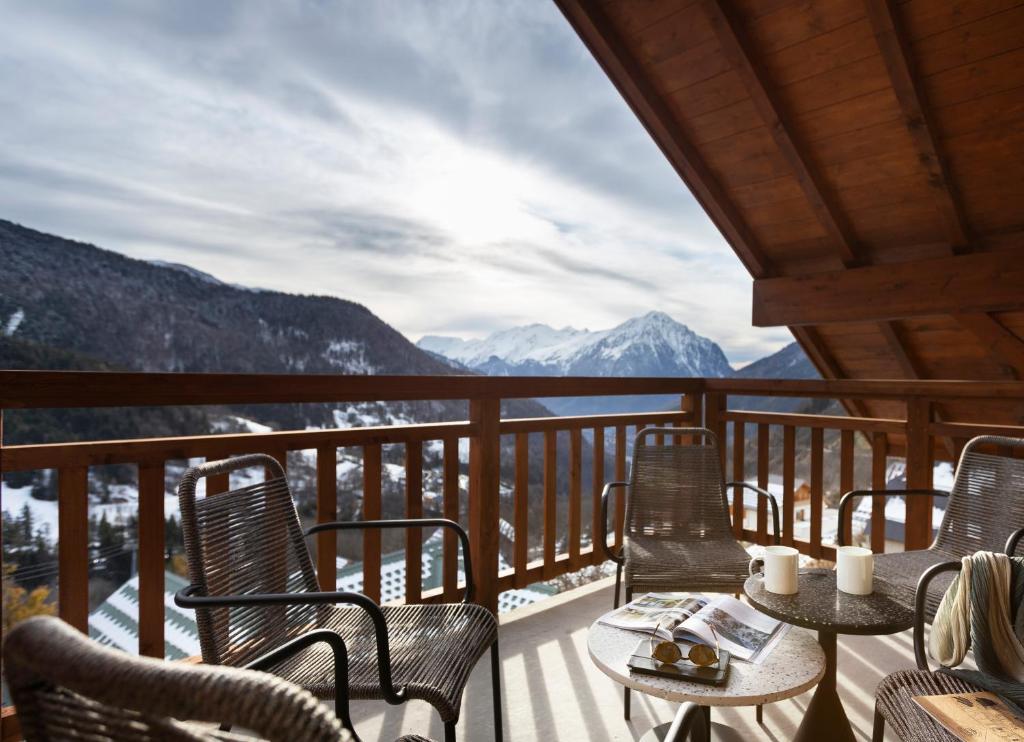 d'un balcon avec des chaises et des tables offrant une vue sur les montagnes. dans l'établissement TERRESENS - Le Saphir, à Vaujany