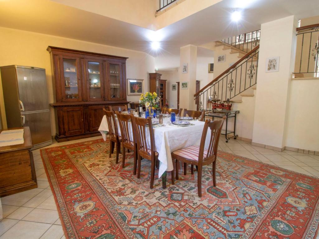 une salle à manger avec une table et des chaises sur un tapis dans l'établissement Villa La Danza by Interhome, à Zampani 26 autres photos
