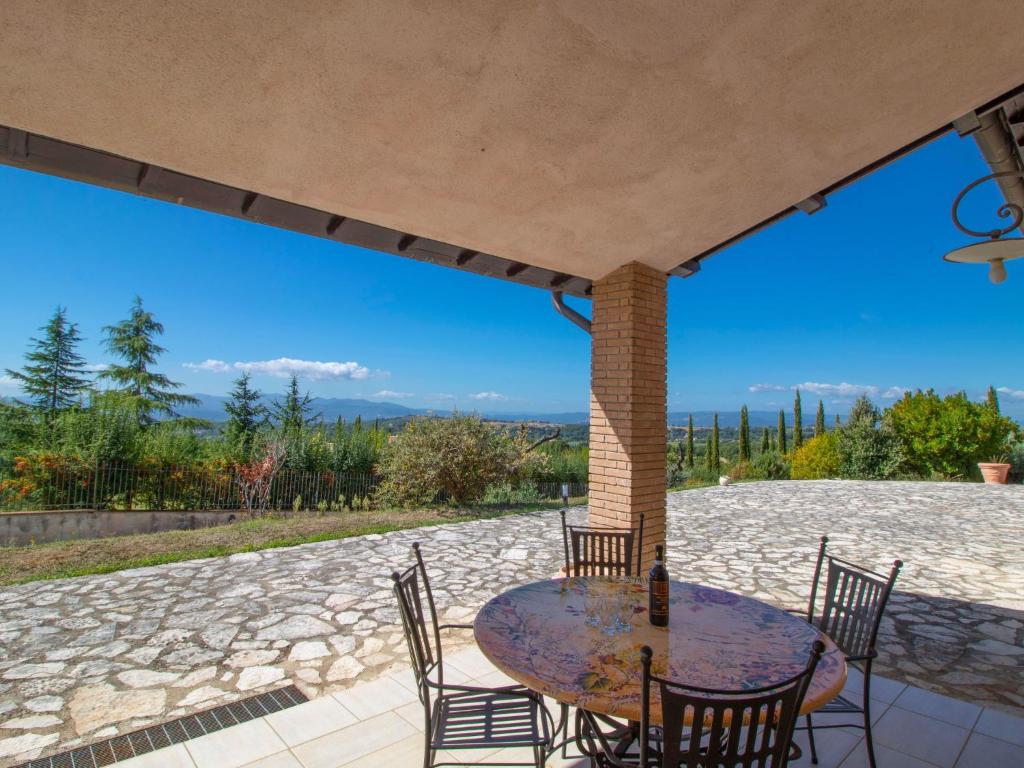 une terrasse en pierre avec une table et des chaises. dans l'établissement Villa La Danza by Interhome, à Zampani