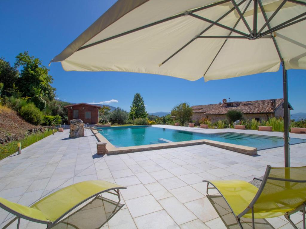 une piscine avec deux chaises et un parasol dans l'établissement Villa La Danza by Interhome, à Zampani
