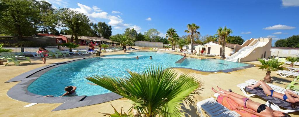 une grande piscine avec des gens dans un complexe hôtelier dans l'établissement Camping Domaine Du Golfe De Saint Tropez, à Grimaud
