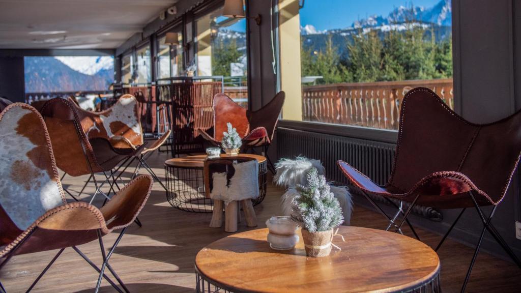 une rangée de chaises et de tables sur une terrasse dans l'établissement Hôtel Arbois Bettex, à Saint-Gervais-les-Bains