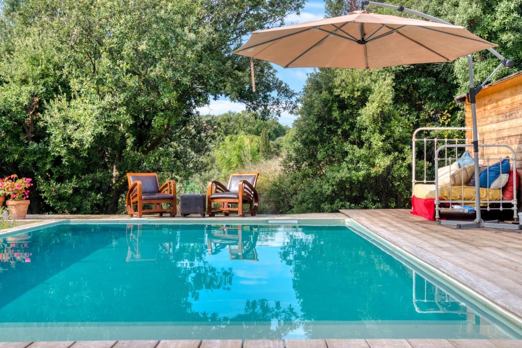 une piscine avec des chaises et un parasol dans l'établissement Glamping Tent Joy, à Vélieux