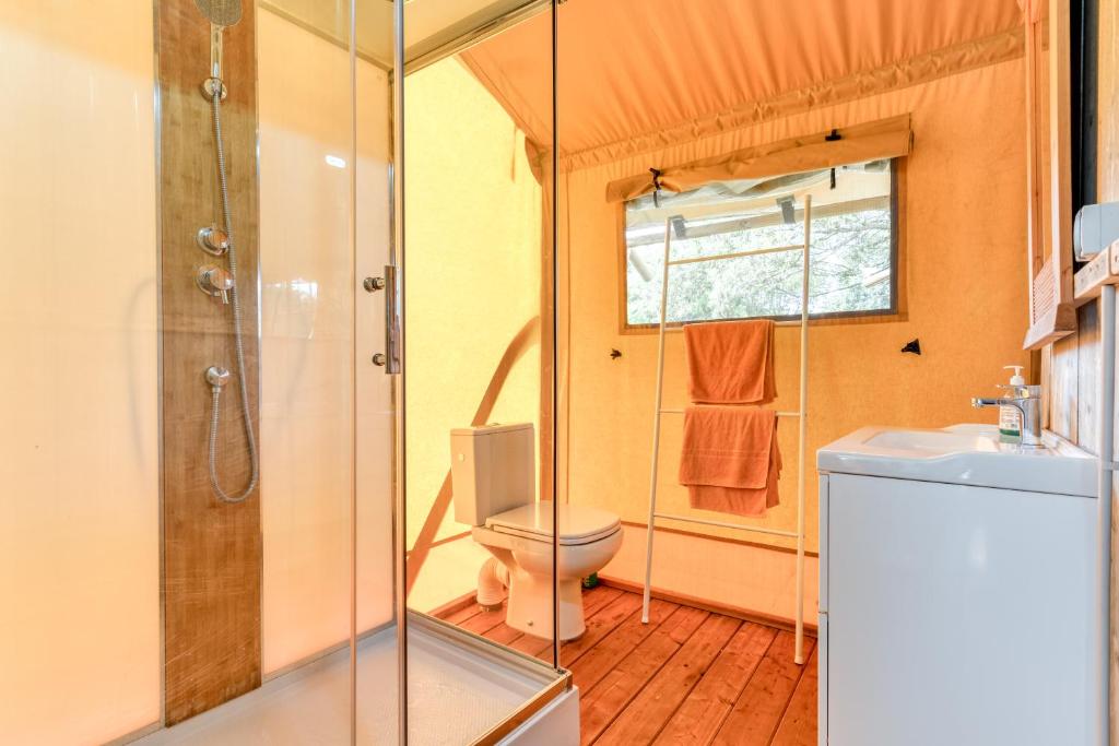 une salle de bain avec une douche, des toilettes et un lavabo dans l'établissement Glamping Tent Joy, à Vélieux