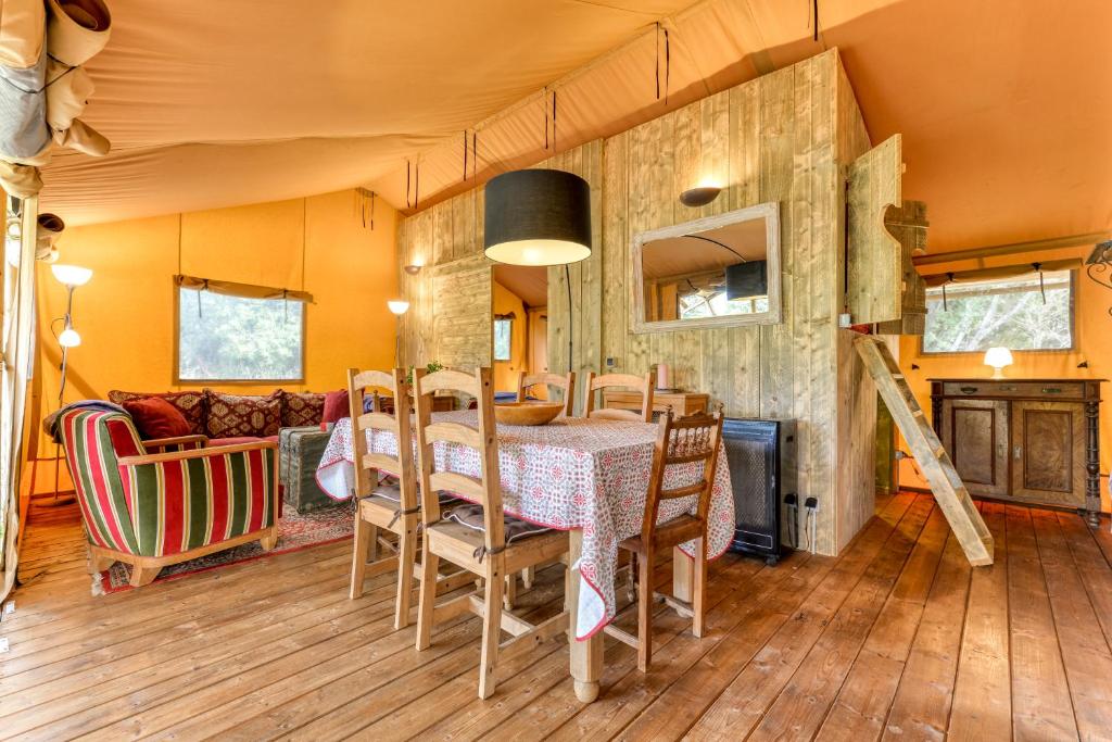 une salle à manger avec une table et des chaises dans l'établissement Glamping Tent Joy, à Vélieux