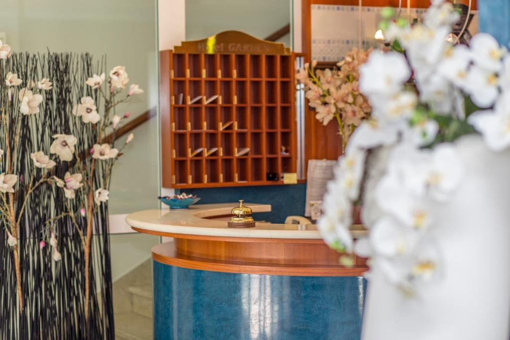 La salle de bains est pourvue d'un lavabo et d'un comptoir fleuri. dans l'établissement Hotel Garden, à Riccione