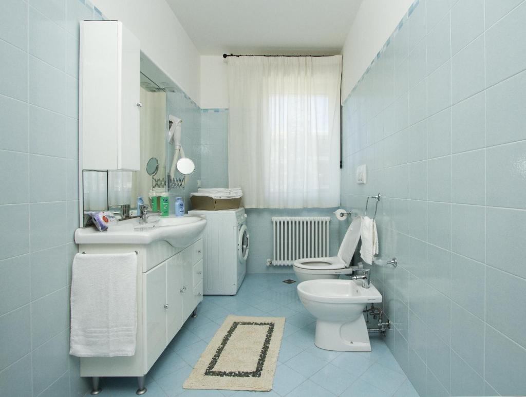 une salle de bain bleue avec des toilettes et un lavabo dans l'établissement Residence I Delfini, à Cupra Marittima
