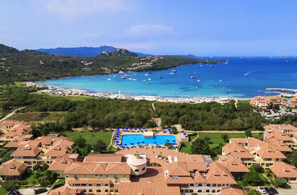- une vue aérienne sur un complexe et l'eau dans l'établissement Colonna Beach Hotel Marinella, à Marinella