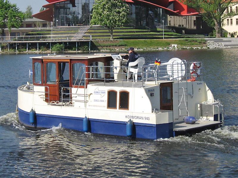 un bateau bleu et blanc dans l'eau dans l'établissement Kuhnle-Tours Niderviller, à Niderviller