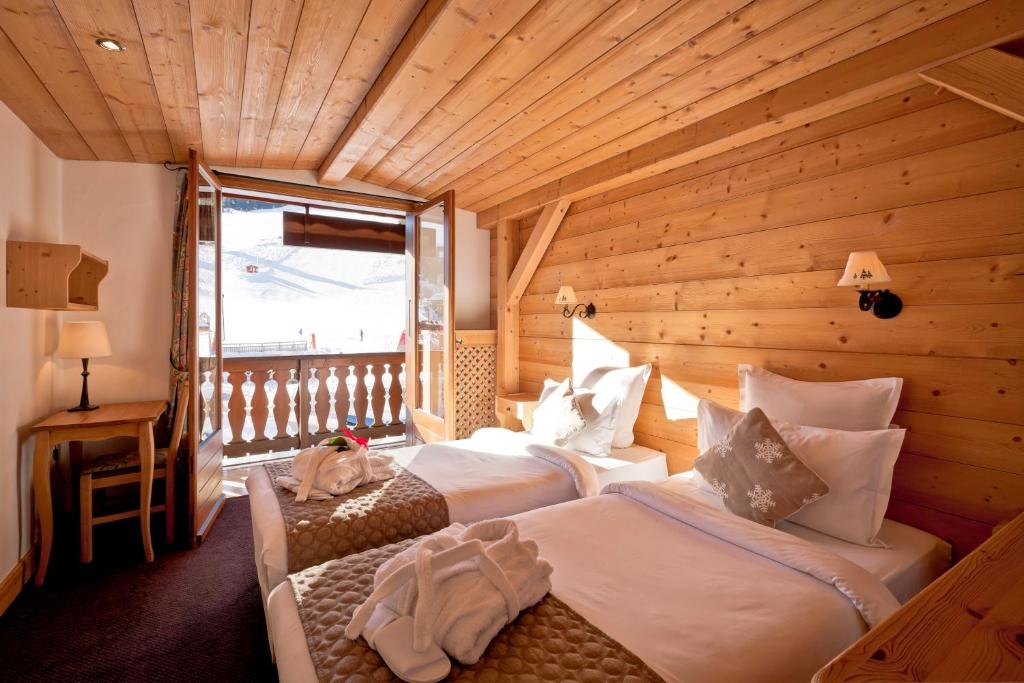 - une chambre avec 2 lits dans une pièce en bois dans l'établissement Hotel les Flocons, à Courchevel 37 autres photos