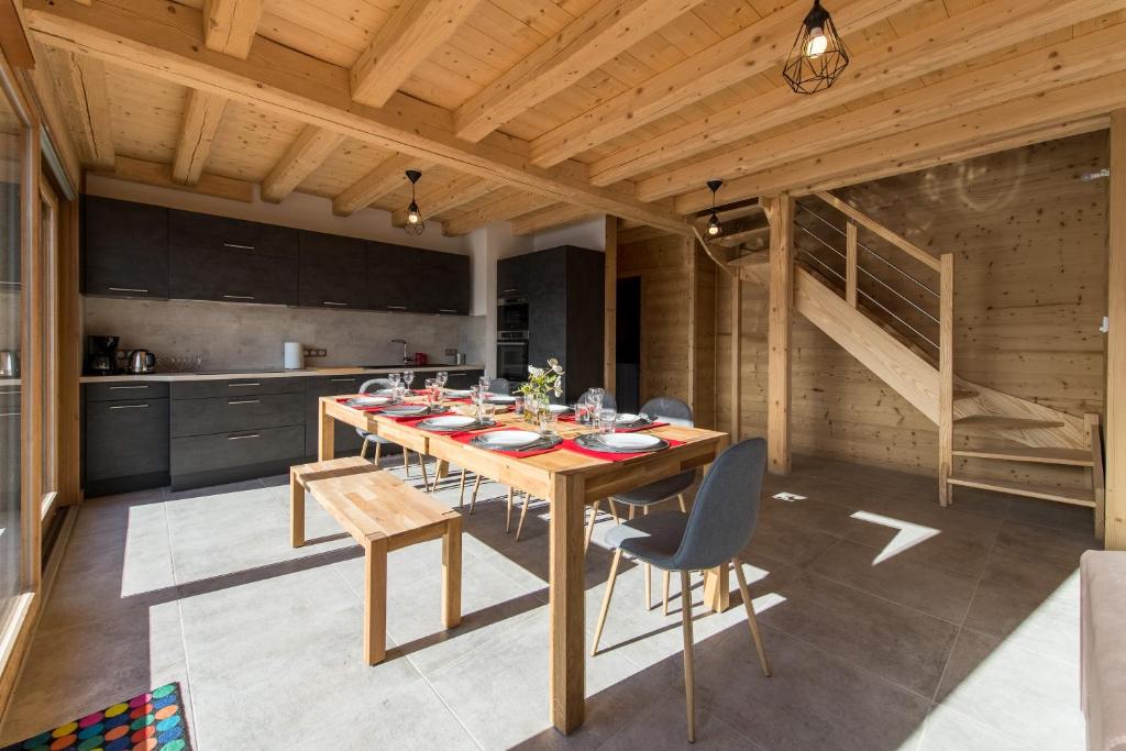une salle à manger avec une table et des chaises dans une cuisine dans l'établissement ODYSSEE B301 Duplex mansarde sur les pistes, vue panoramique, à La Toussuire