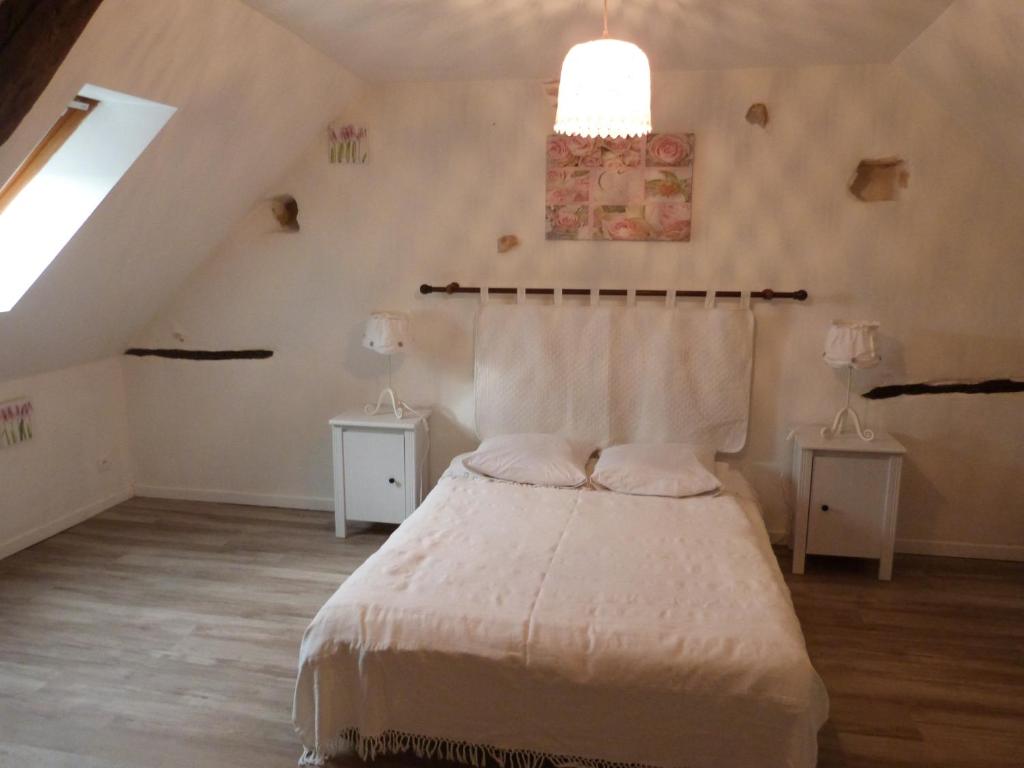 une chambre avec un lit avec un couvre-lit blanc dans l'établissement Gîte avec Piscine proche de St Cirq Lapopie, à Berganty