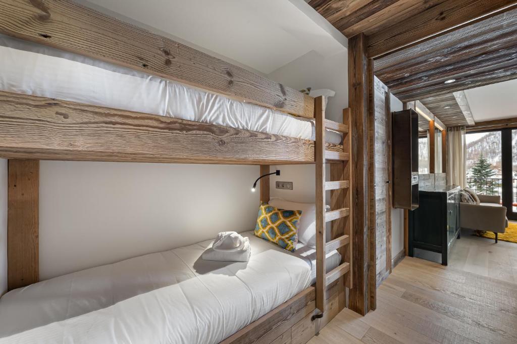 quelques lits superposés dans une chambre dans l'établissement Appartement Flocon - LES CHALETS COVAREL, à Val dʼIsère