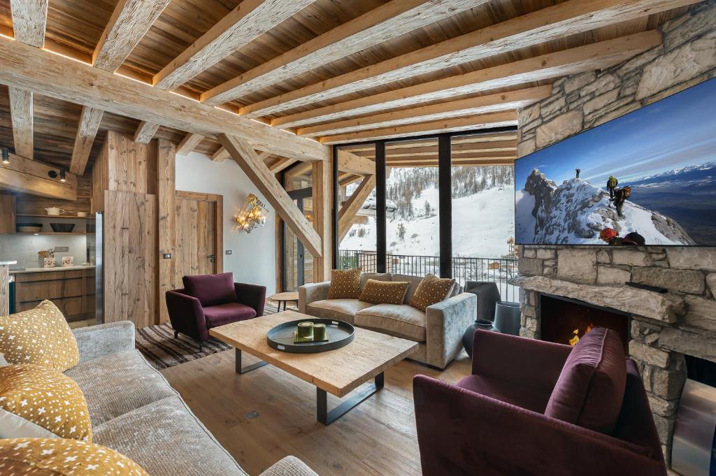 un salon avec une cheminée et une télévision dans l'établissement Penthouse Flèche - LES CHALETS COVAREL, à Val dʼIsère