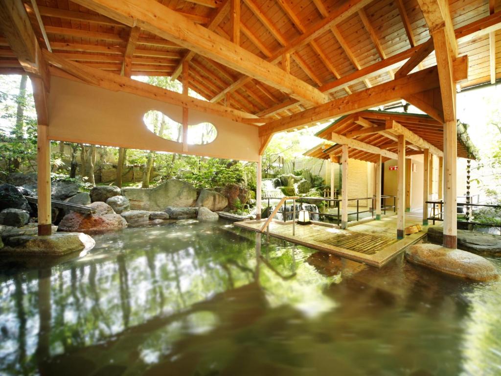 une piscine intérieure dans une maison avec un toit dans l'établissement Rurikoh, à Kaga