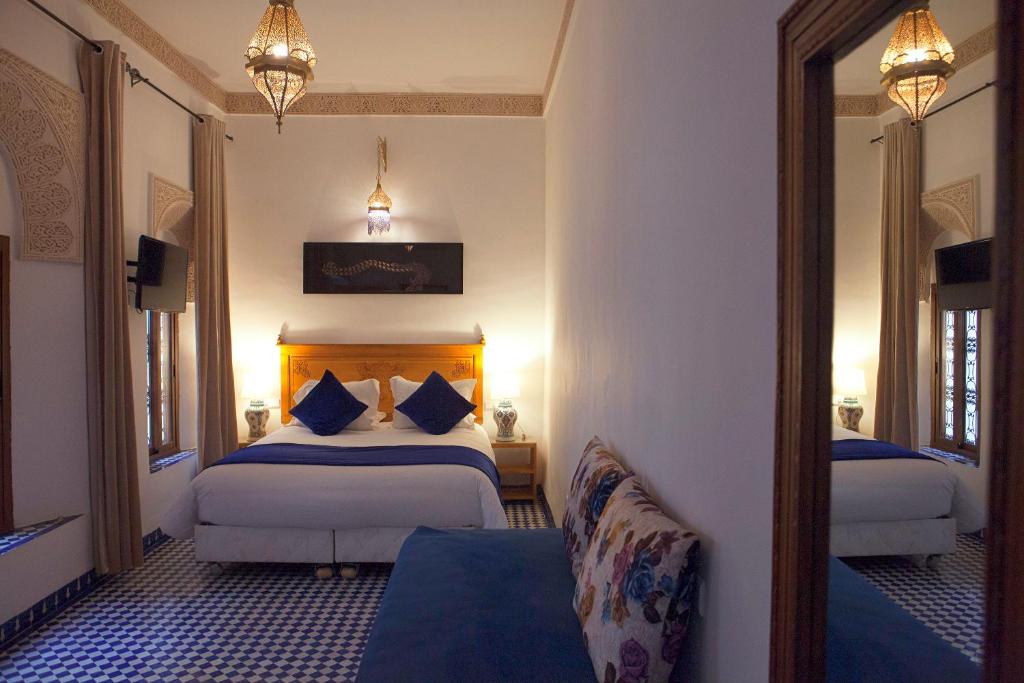 une chambre d'hôtel avec deux lits et un miroir dans l'établissement Dar D'or Fes, à Fès