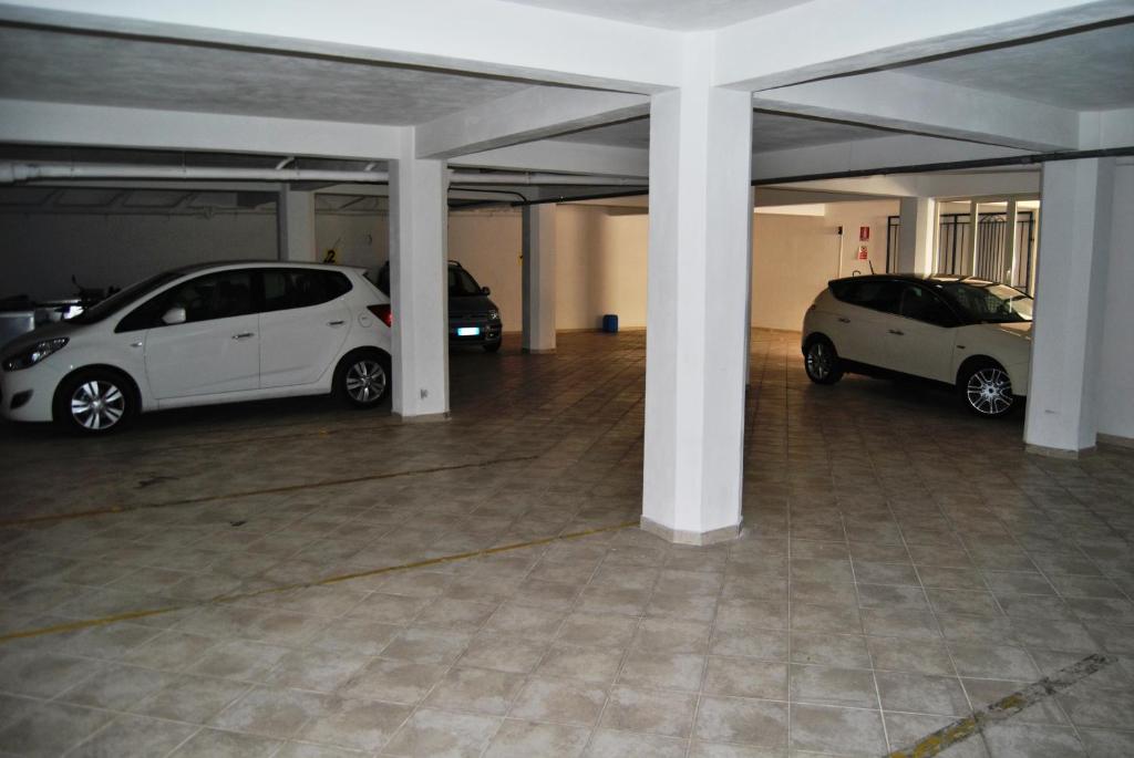 deux voitures blanches garées dans un parking dans l'établissement Hotel Sicilya, à San Vito Lo Capo