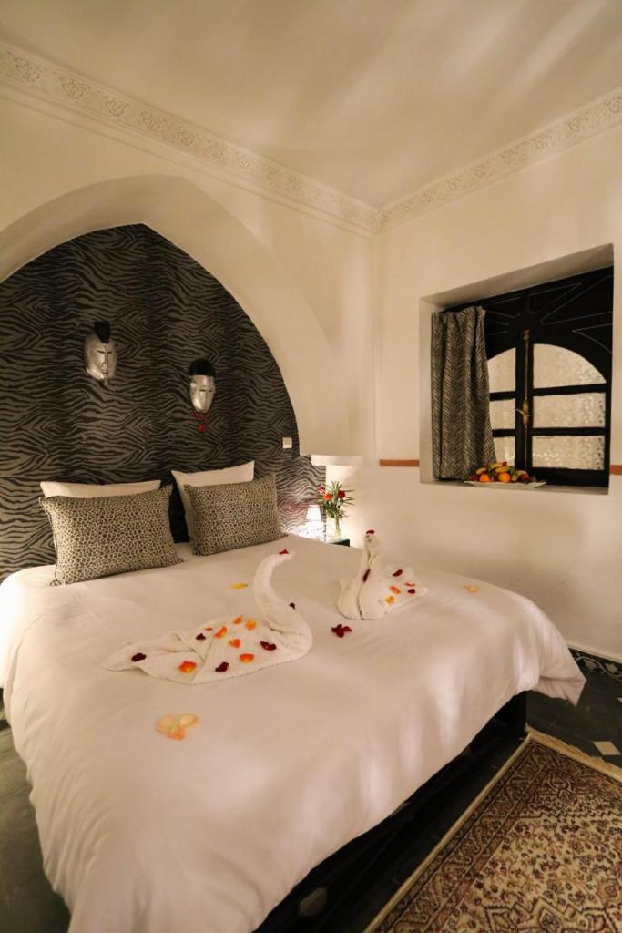 - une chambre avec un grand lit blanc orné de fleurs dans l'établissement La Voûte Étoilée, à Marrakech 37 autres photos