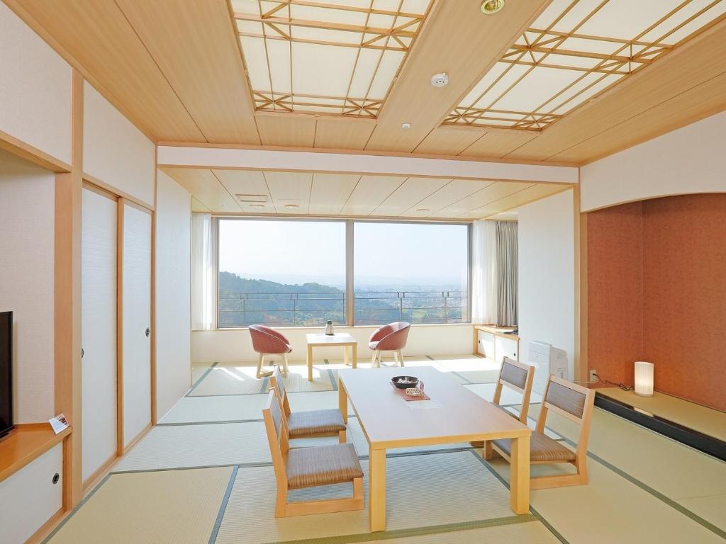 une pièce avec une table et des chaises et une grande fenêtre dans l'établissement Onyado Toho, à Aizuwakamatsu