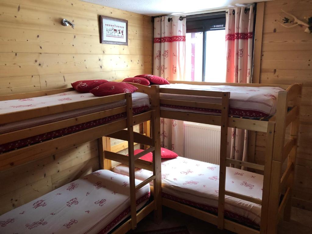une chambre avec trois lits superposés dans une cabine dans l'établissement CERRO TORRE PLAGNE Du Samedi Au Samedi, à Aime La Plagne
