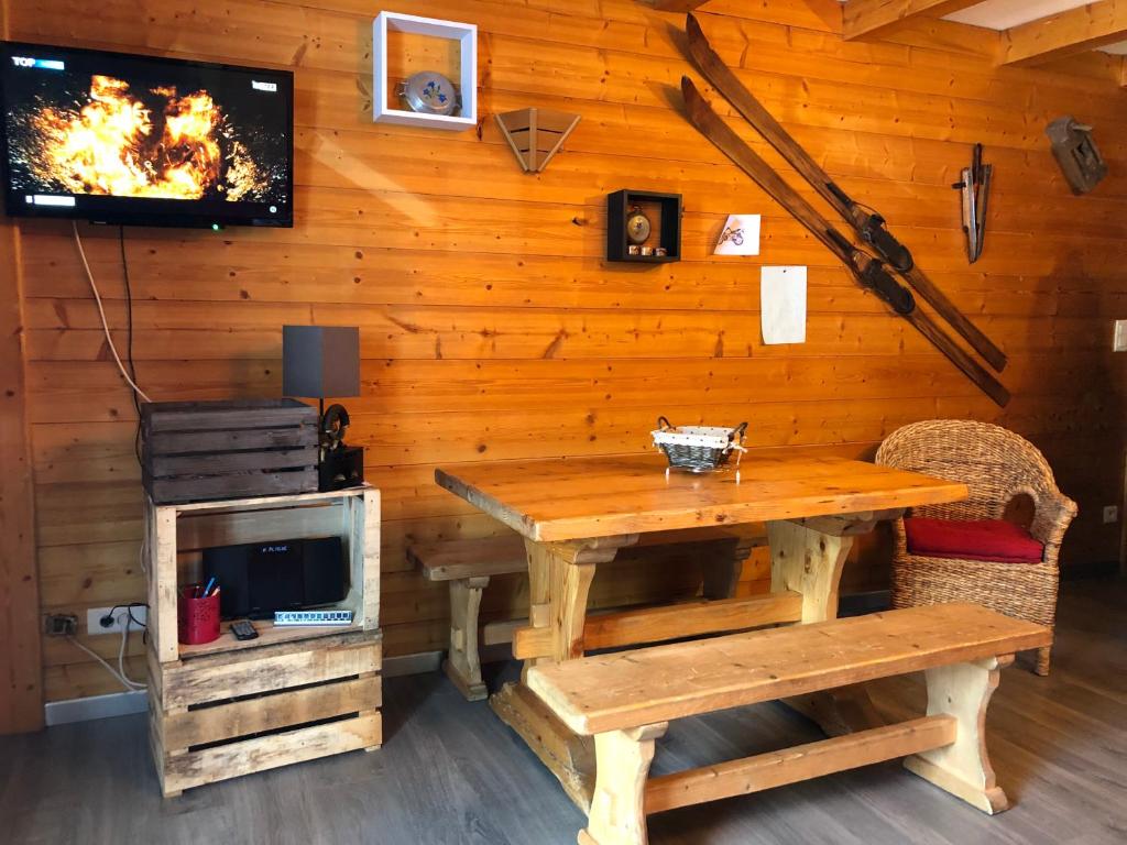 une salle à manger en bois avec une table et une télévision dans l'établissement CERRO TORRE PLAGNE Du Samedi Au Samedi, à Aime La Plagne