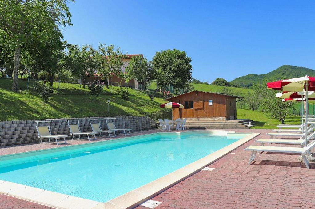 une piscine avec des chaises et des parasols ainsi qu'une maison dans l'établissement Casale Lucy, à Pergola