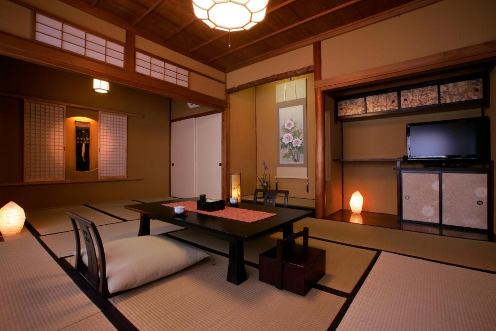 - un salon avec une table et une télévision dans l'établissement Wafu-no-Yado MASUYA, à Yamanouchi