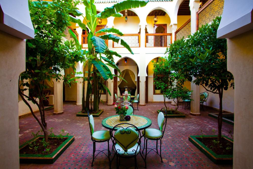 un patio avec une table et des chaises dans un bâtiment dans l'établissement Riad Tidar by Phoenix, à Marrakech
