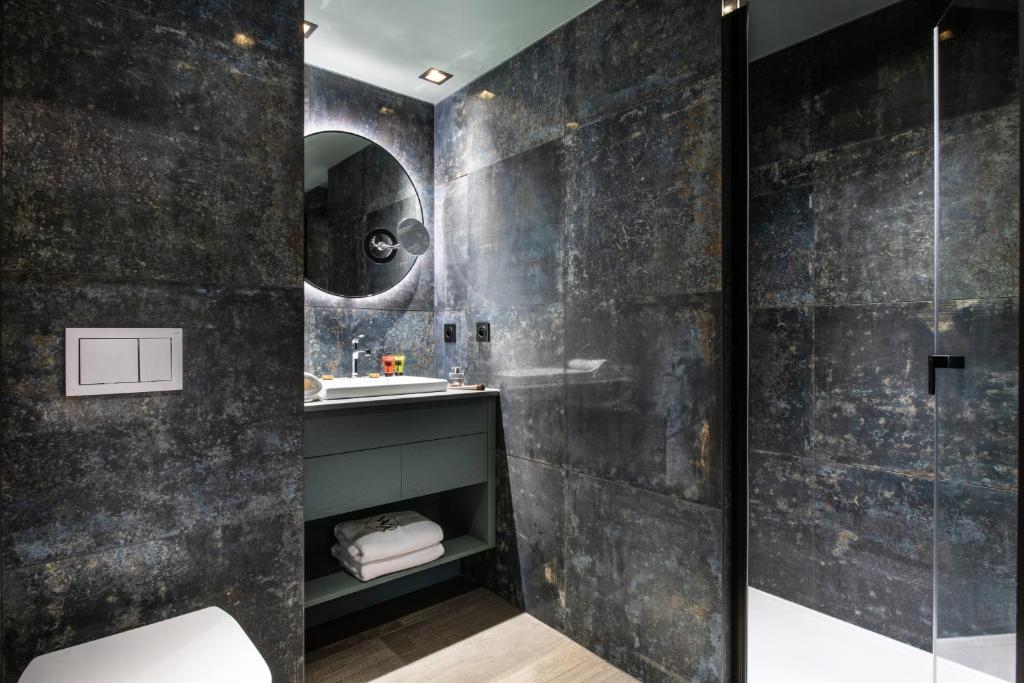une salle de bain avec un lavabo et une douche dans l'établissement Chalets Izia - Village Montana, à Val dʼIsère