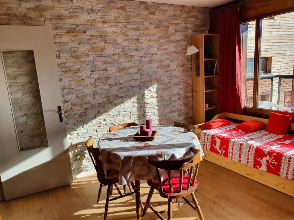 Cette chambre comprend une table avec des chaises et un lit. dans l'établissement Studio Queyrelet 1 pied des pistes avec balcon & vue 2-4 personnes, à Orcières